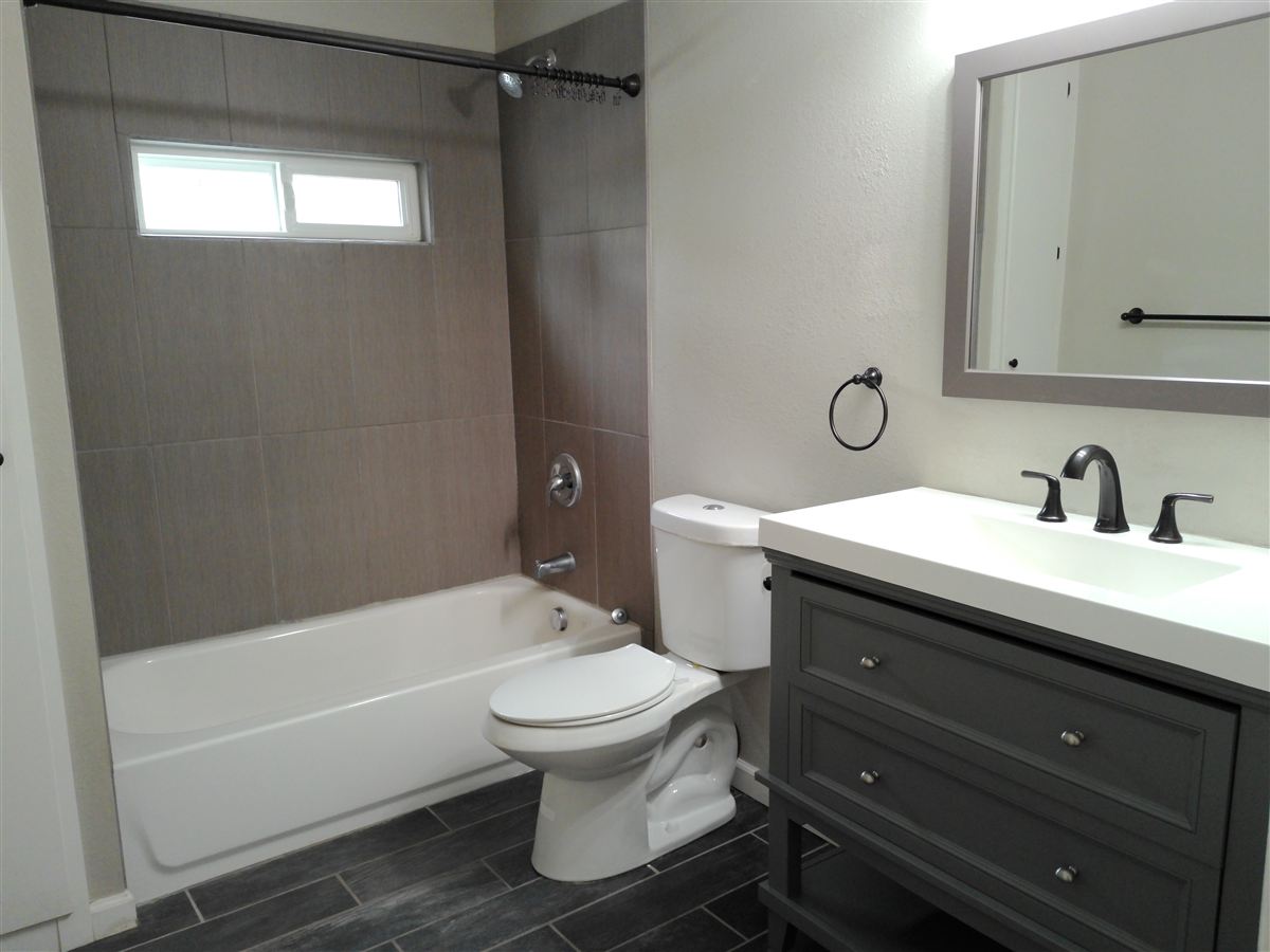 Main-level bath with tub, tile surround and stylish vanity
