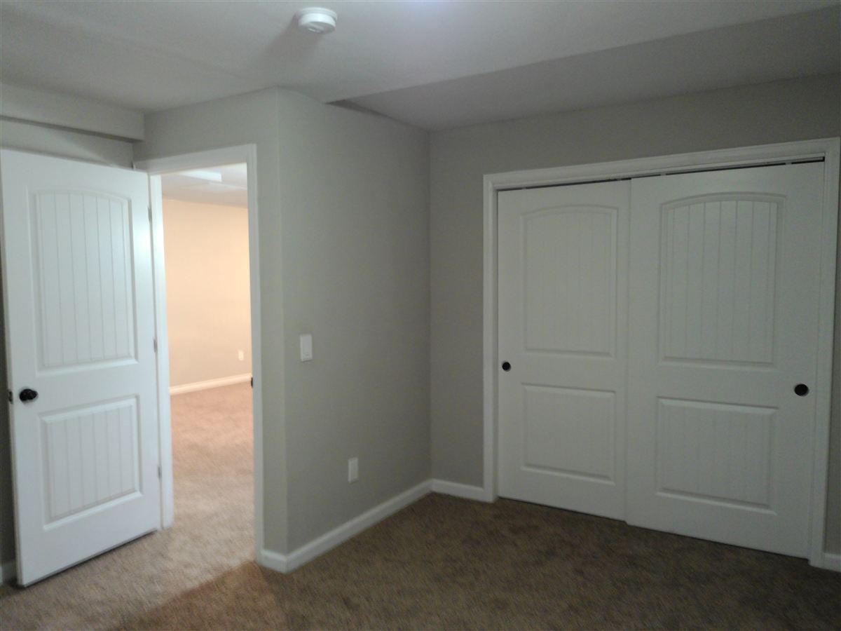 Lower-level bedroom with sliding closet doors